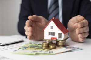 Modellino di casa appoggiato su delle banconote