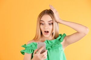 donna stupita a bocca aperta con il cellulare in mano