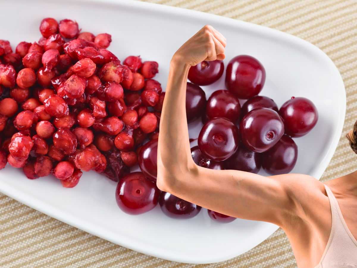sfondo noccioli di ciliegie e frutto e braccio muscolo donna alzato
