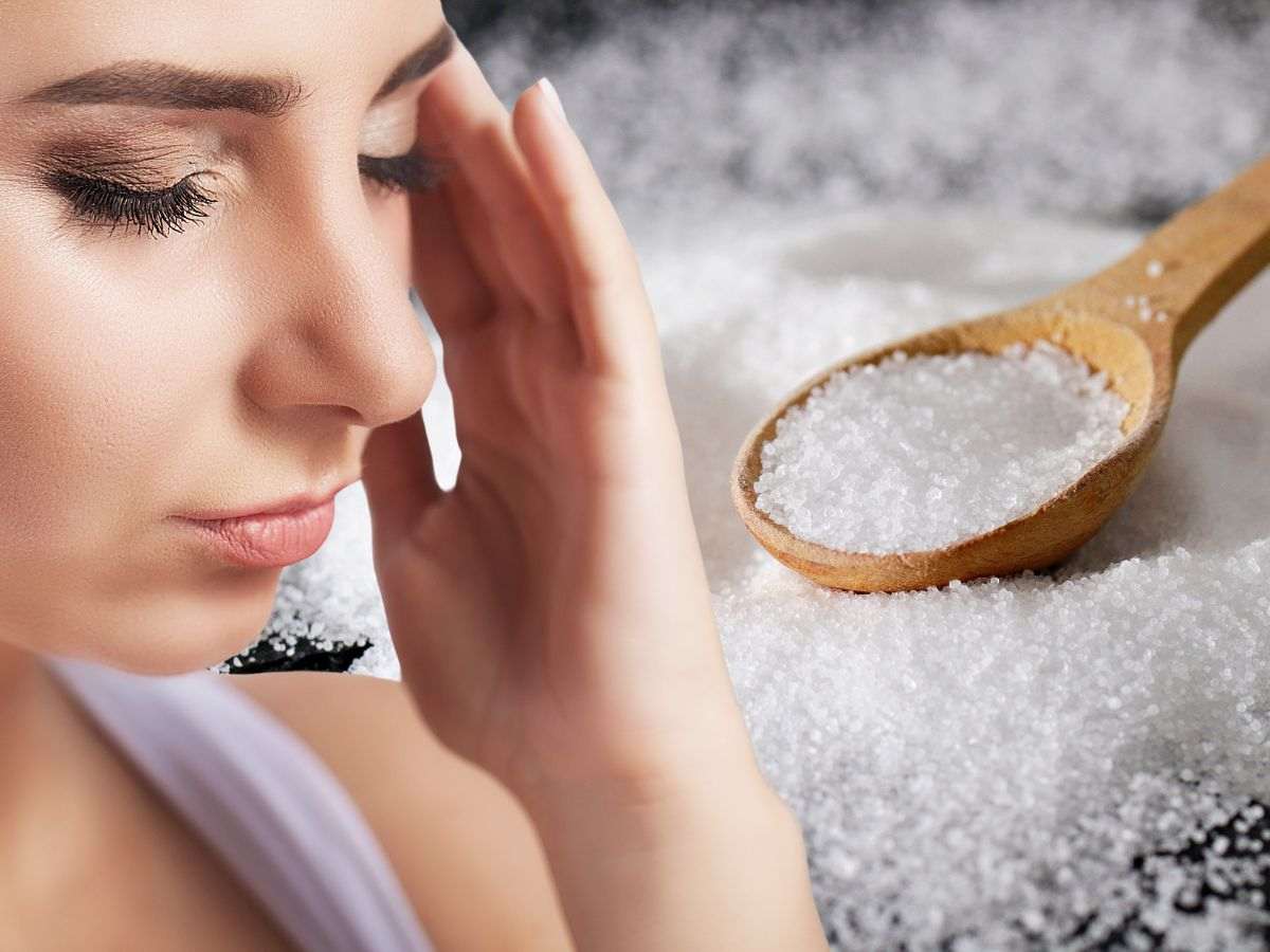 Donna con il mal di testa e cucchiaio di sale