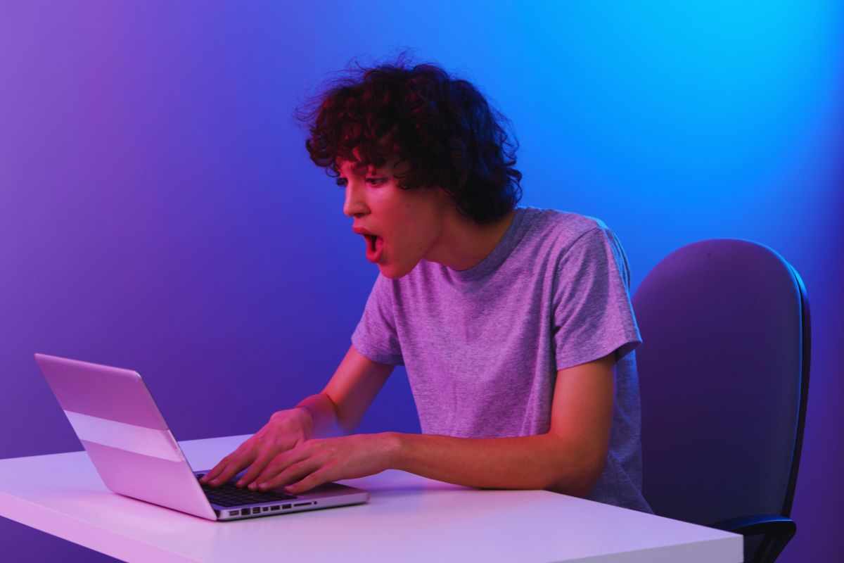Ragazzo con espressione sbalordita mentre utilizza un PC