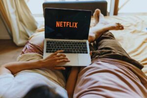 Coppia che guarda Netflix dal letto tramite un laptop