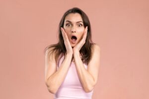 donna stupita con la bocca aperta e le mani sulle guance