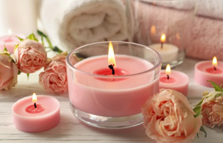 candele rosa circondate da rose