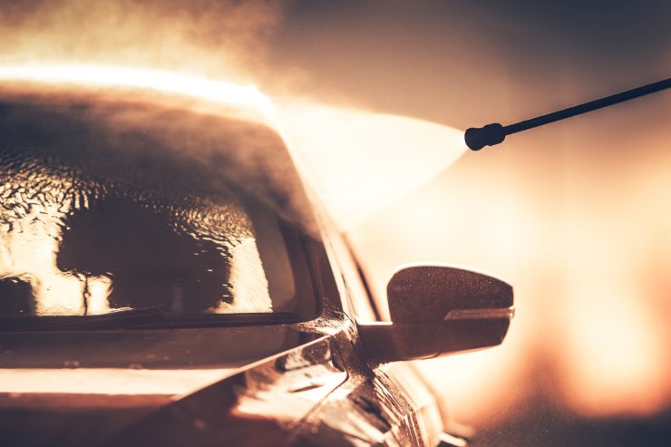 auto in autolavaggio con spruzzo d'acqua della lancia